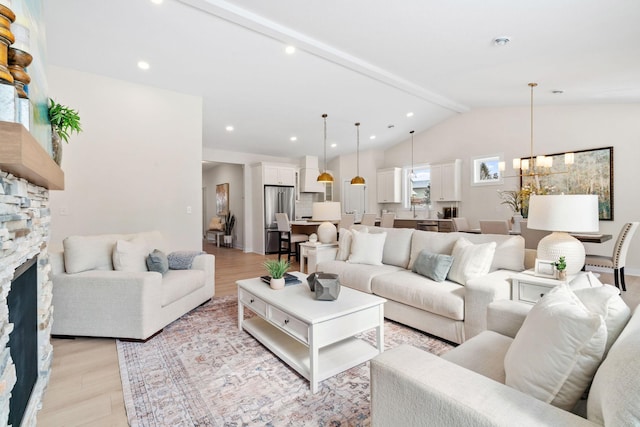 living room featuring a stone fireplace, recessed lighting, vaulted ceiling with beams, and light wood-style floors
