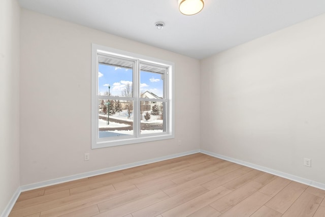 spare room featuring light wood-style flooring and baseboards