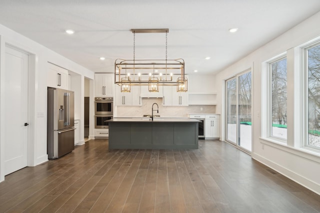 kitchen featuring backsplash, wine cooler, white cabinets, stainless steel appliances, and a sink