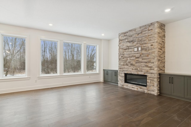 unfurnished living room featuring dark wood-style floors, recessed lighting, a fireplace, and baseboards