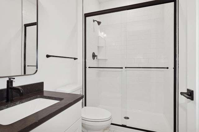 bathroom with vanity, toilet, and a shower stall