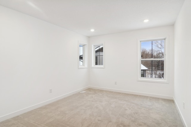 unfurnished room with recessed lighting, baseboards, and light colored carpet