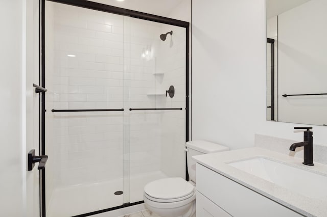 bathroom featuring a stall shower, toilet, and vanity