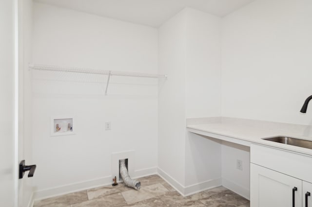 clothes washing area featuring washer hookup, a sink, hookup for a gas dryer, cabinet space, and baseboards