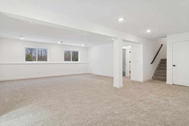 below grade area with recessed lighting, stairway, light colored carpet, and baseboards