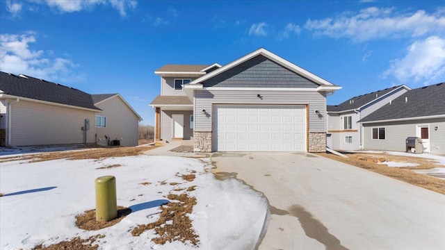 craftsman-style home featuring stone siding, concrete driveway, and an attached garage