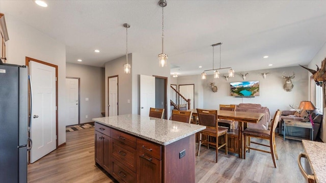 kitchen with light wood-style flooring, recessed lighting, freestanding refrigerator, decorative light fixtures, and open floor plan