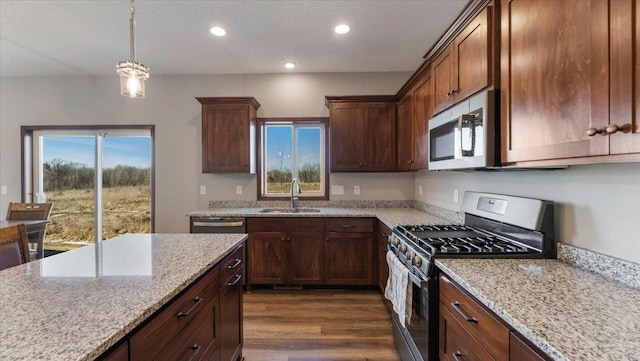 kitchen featuring light stone countertops, recessed lighting, a sink, dark wood-type flooring, and appliances with stainless steel finishes