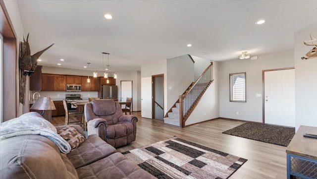 living area featuring stairway, recessed lighting, light wood-style flooring, and baseboards