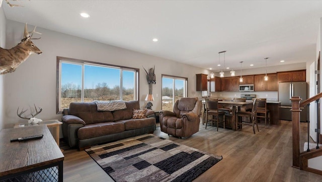 living room with recessed lighting, stairs, and light wood-style floors