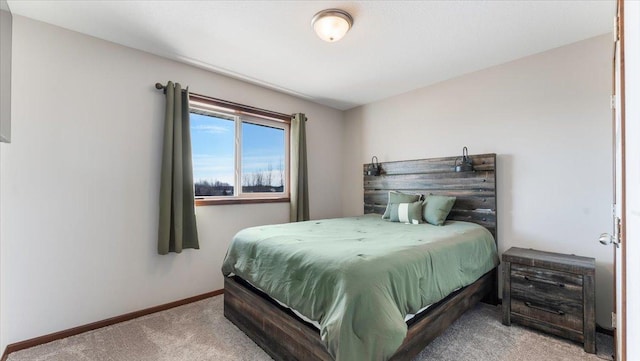 bedroom featuring light colored carpet and baseboards