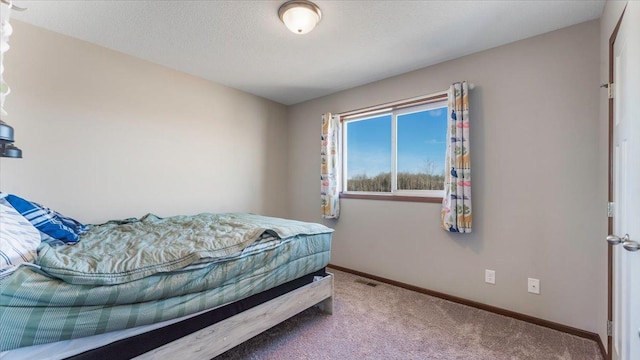 carpeted bedroom with baseboards, visible vents, and a textured ceiling