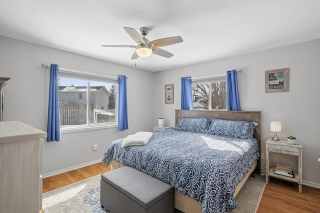 bedroom featuring a ceiling fan, wood finished floors, and baseboards