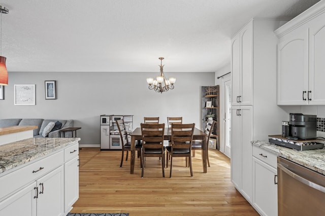 dining space featuring an inviting chandelier and light wood-style floors