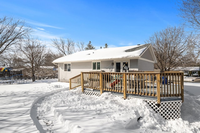 snow covered rear of property with a wooden deck