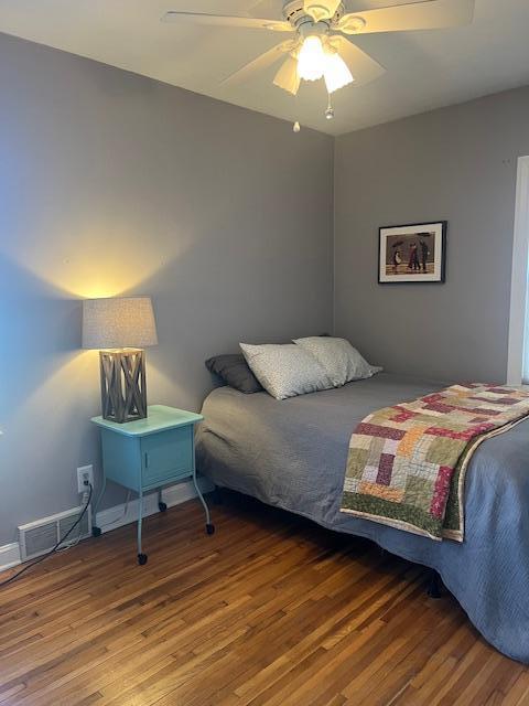 bedroom with visible vents, a ceiling fan, and wood finished floors