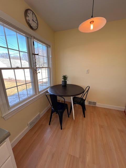 dining space with visible vents, light wood-type flooring, and baseboards