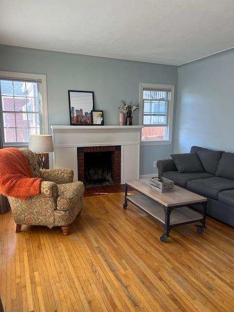 living room with light wood-style flooring, a fireplace, and a wealth of natural light