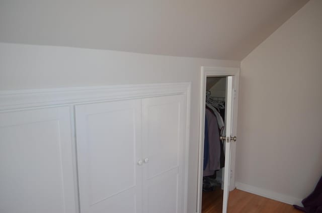 unfurnished bedroom featuring a closet, baseboards, and wood finished floors