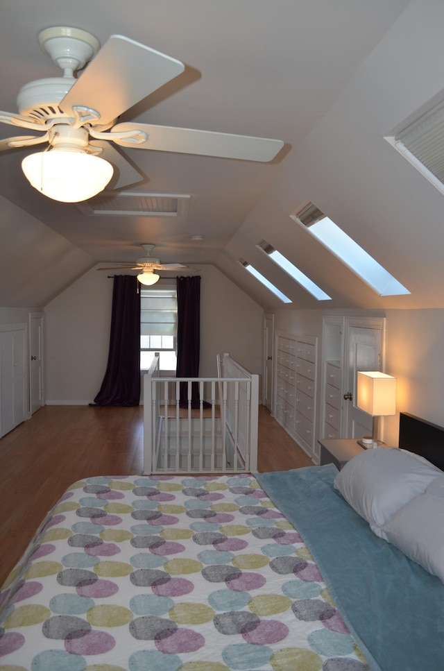 bedroom featuring vaulted ceiling, wood finished floors, and visible vents