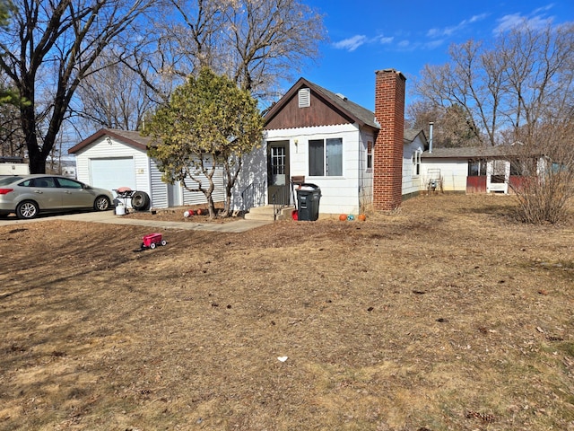 view of front of property featuring a garage, board and batten siding, a chimney, and entry steps