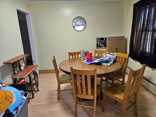 dining area with baseboards, light wood-type flooring, and ornamental molding