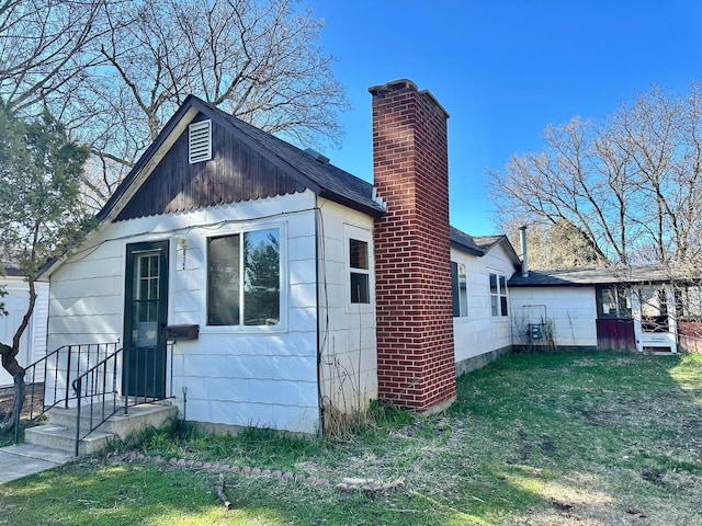 615 4th St W, Park Rapids, MN 56470 - rear view of house featuring a lawn, roof with shingles, and a chimney