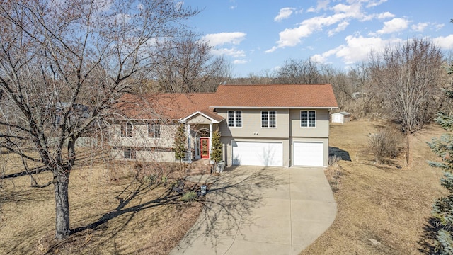 tri-level home with concrete driveway and a garage