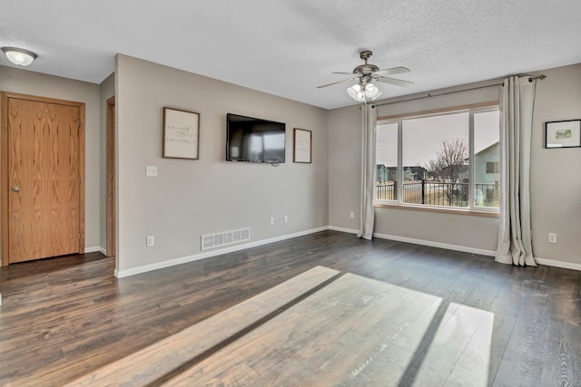 unfurnished room with visible vents, dark wood-type flooring, a ceiling fan, a textured ceiling, and baseboards