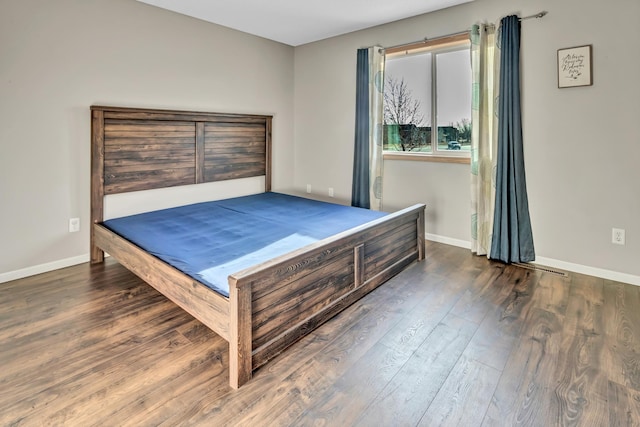 bedroom with baseboards and wood finished floors