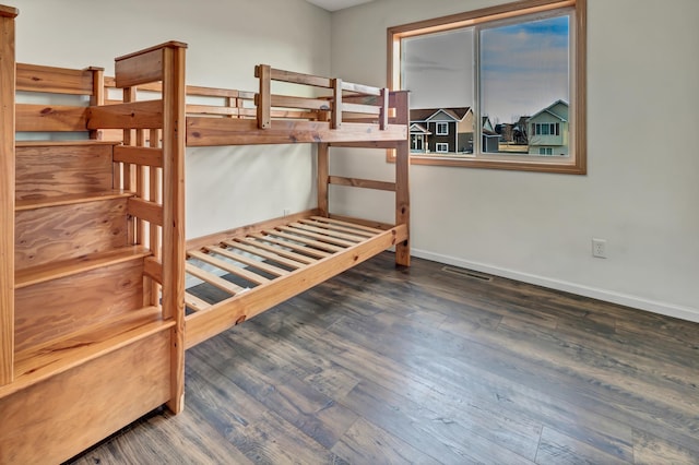 bedroom featuring visible vents, baseboards, and wood finished floors