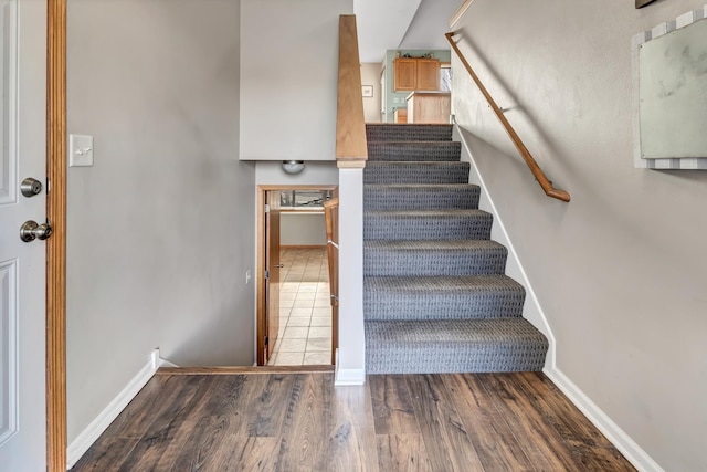 stairs with wood finished floors and baseboards