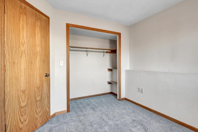 unfurnished bedroom featuring a closet, baseboards, and carpet flooring