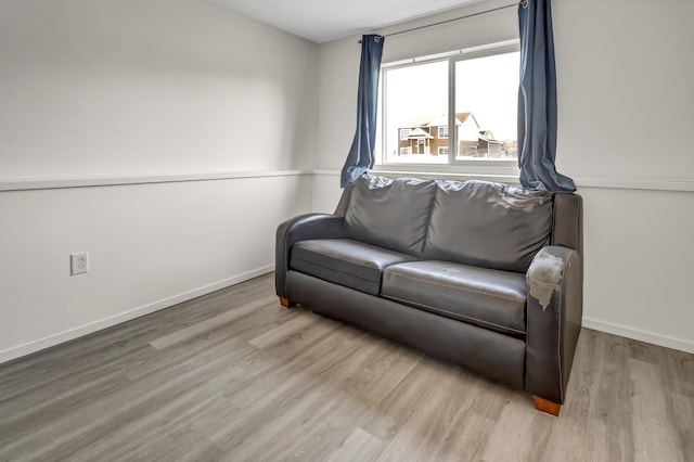 living area with baseboards and wood finished floors