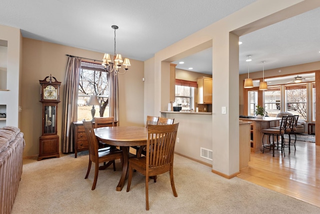 dining space featuring visible vents, light carpet, ceiling fan with notable chandelier, recessed lighting, and baseboards