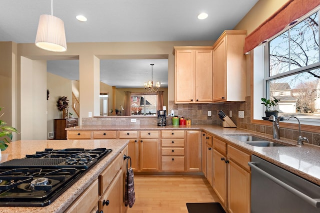 kitchen with light brown cabinets, black gas cooktop, stainless steel dishwasher, light wood-style floors, and a sink