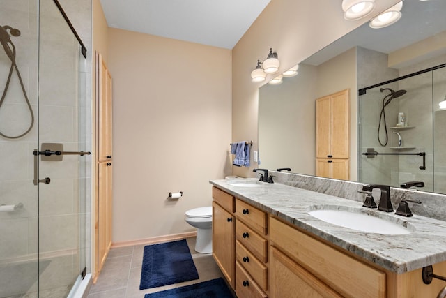 full bath with a sink, a stall shower, double vanity, and tile patterned flooring