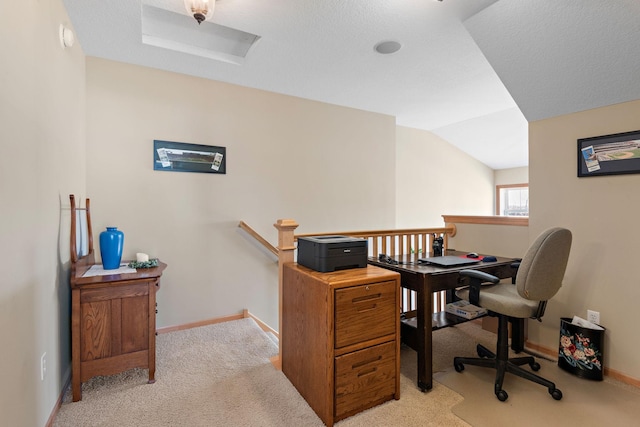 office area featuring light carpet, attic access, baseboards, and vaulted ceiling