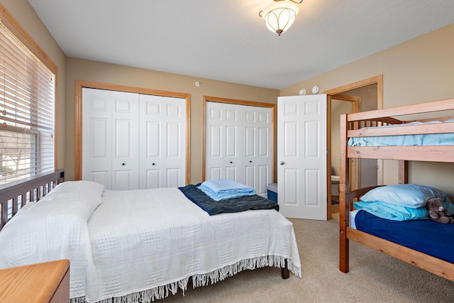 bedroom with carpet and multiple closets