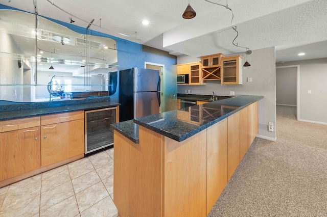 kitchen with glass insert cabinets, wine cooler, a peninsula, stainless steel appliances, and a sink