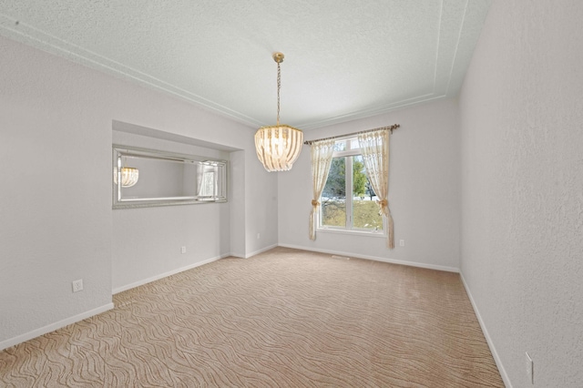 spare room with a textured ceiling, an inviting chandelier, carpet flooring, baseboards, and a textured wall