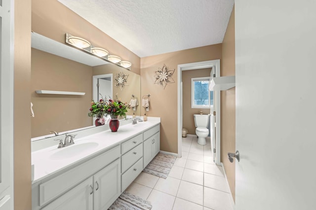 full bathroom featuring tile patterned floors, toilet, a sink, a textured ceiling, and double vanity