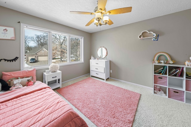 bedroom featuring ceiling fan, carpet, baseboards, and a textured ceiling