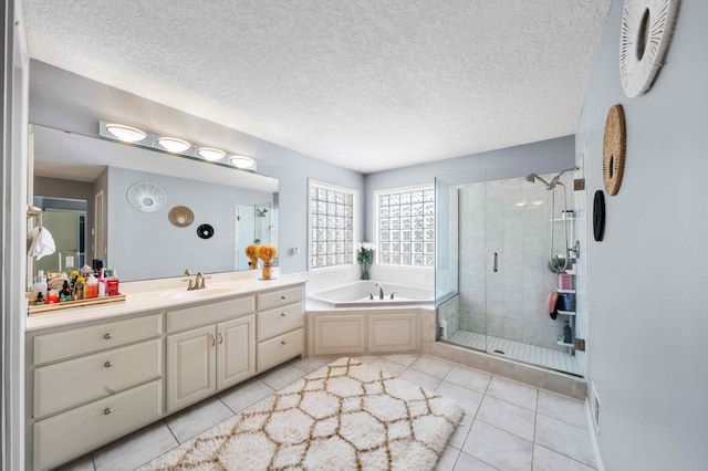 bathroom featuring a textured ceiling, a bath, a shower stall, and tile patterned flooring