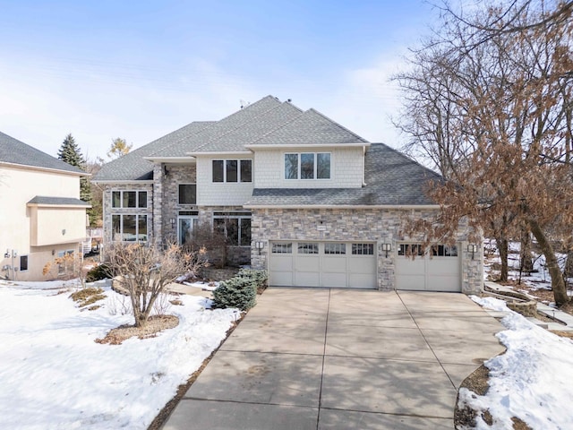 view of front of house featuring stone siding, driveway, an attached garage, and roof with shingles