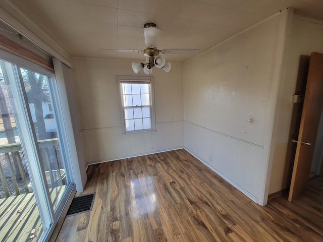 unfurnished dining area featuring visible vents, ceiling fan, and wood finished floors