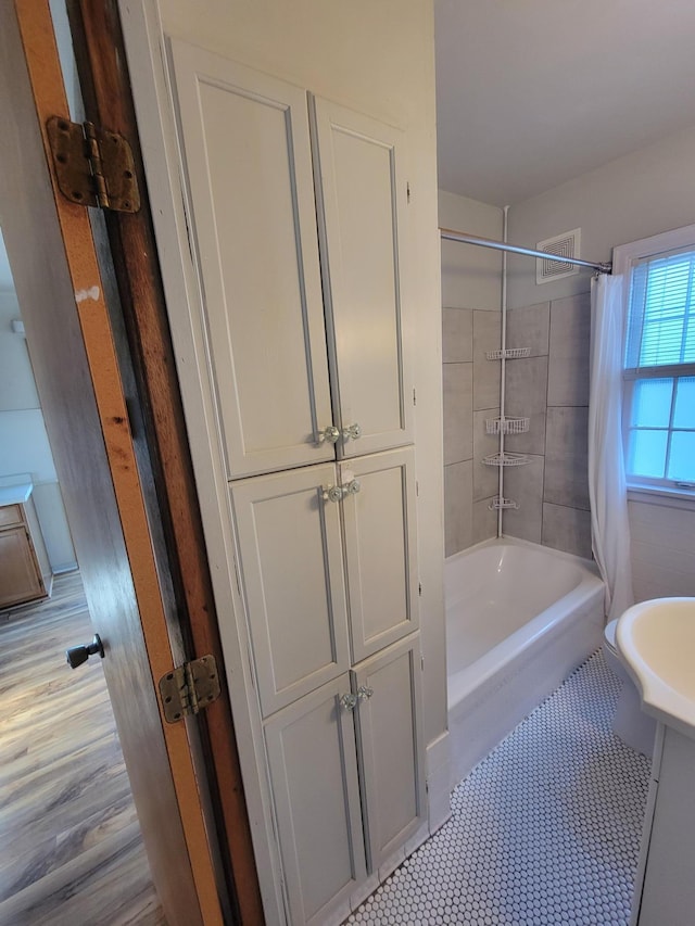 full bath with visible vents and shower / tub combo with curtain