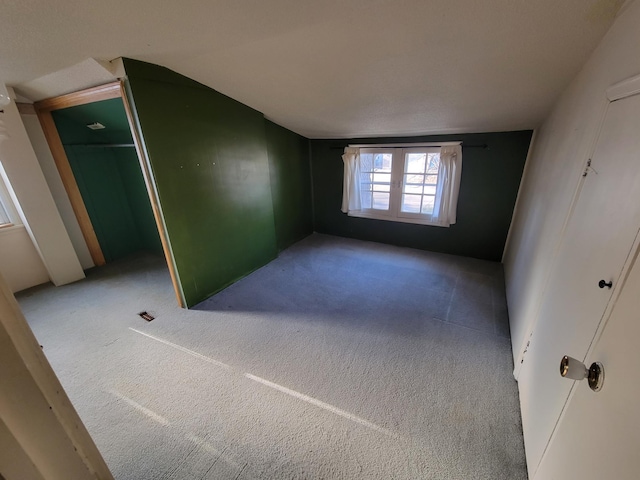 unfurnished bedroom with lofted ceiling and light colored carpet