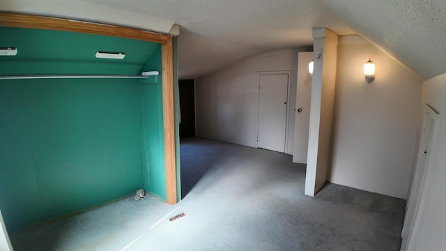 additional living space featuring vaulted ceiling and a textured ceiling