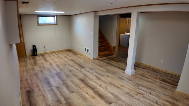 basement featuring visible vents, crown molding, stairway, wood finished floors, and washer / clothes dryer